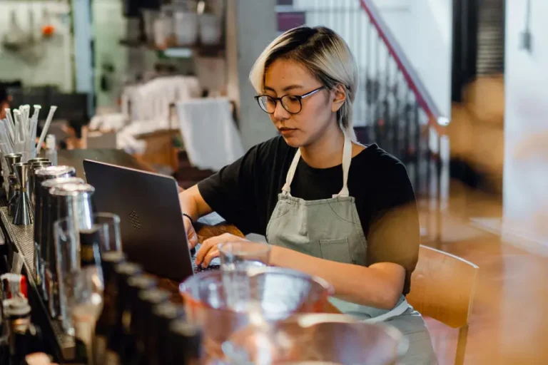 Restaurantmedewerkster neemt reserveringen op tijdens drukke shift.