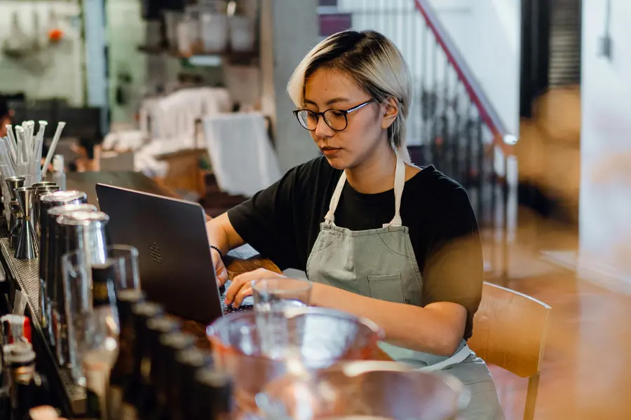 Restaurantmedewerkster neemt reserveringen op tijdens drukke shift.